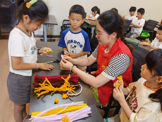 7月12日，在泰州市海陵區(qū)城東街道林湖社區(qū)，泰州市大浦小學“綠葉”暑期公益班的老師正在教孩子們一起做手工2（拍攝者：泰州市大浦中心小學  陳惠婷）.jpg